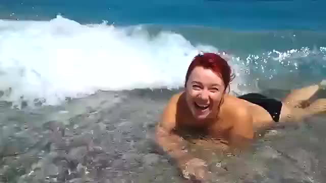 Голая чика плавает в море и греется на пляже