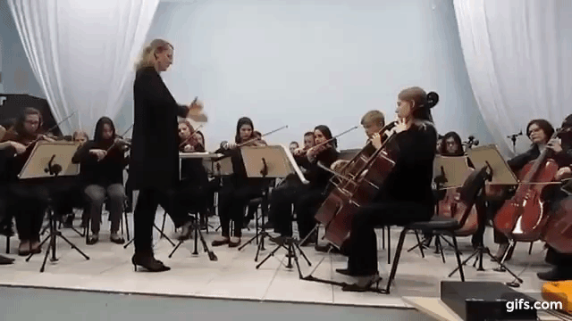 Maestrina Denise regendo a orquestra